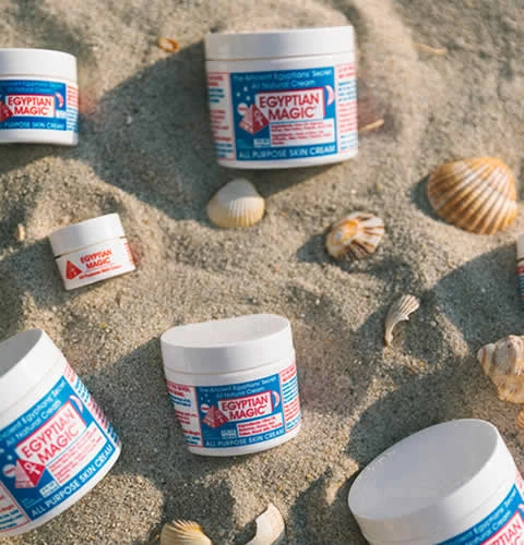 Egyptian Magic - el sueño cosmético hecho realidad - composición de varios productos Egytian Magic i conchas sobre la arena de la playa