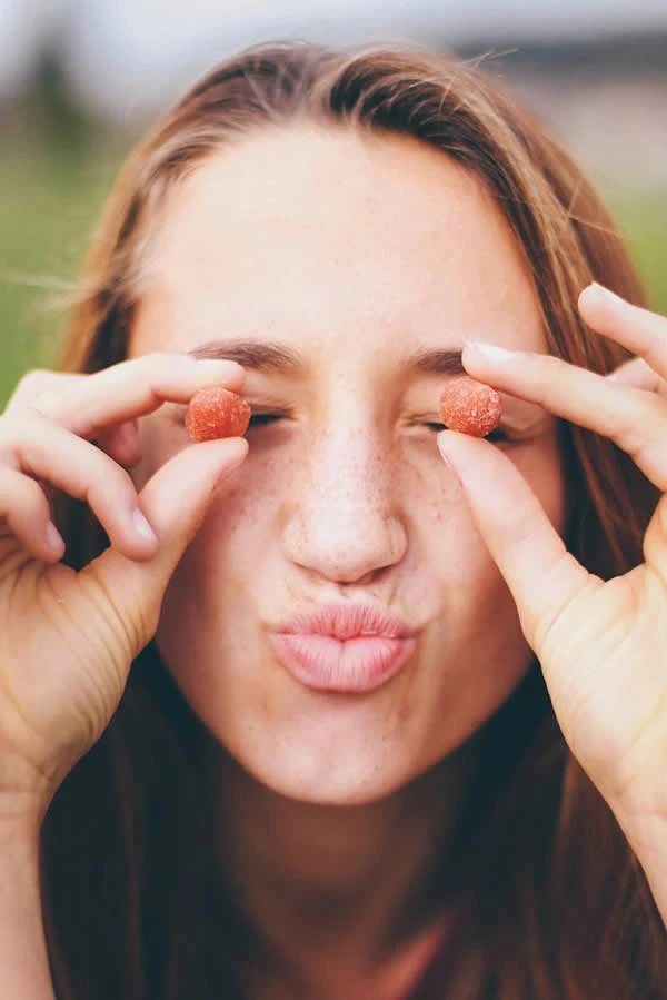 Joven con caramelos Nordic Naturals Omega, posando de forma divertida