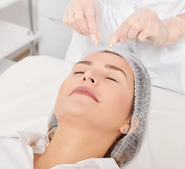 Aceites faciales farmacia aplicando aceites faciales en el rostro de mujer