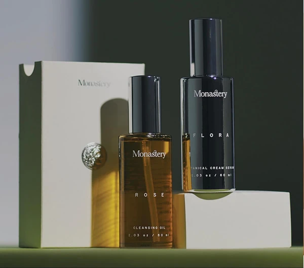 Dos botellas la marca Monastery sobre una mesa, representando la elegancia en cosméticos y belleza