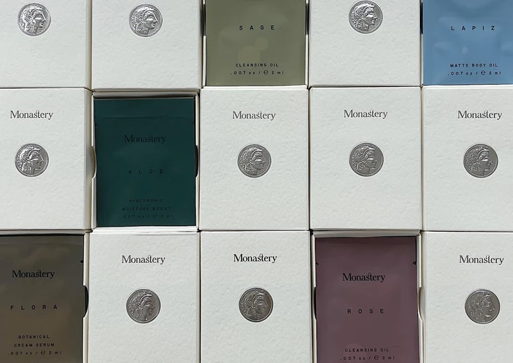 Cajas de colores variados con etiquetas, destacando la línea de productos de belleza y cosméticos de Monastery