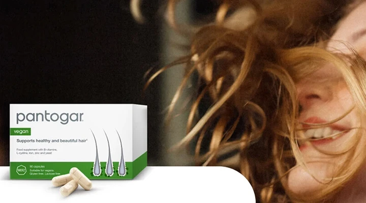 Al fondo, una mujer sonriendo orgullosa de su melena con el pantogar en primer plano