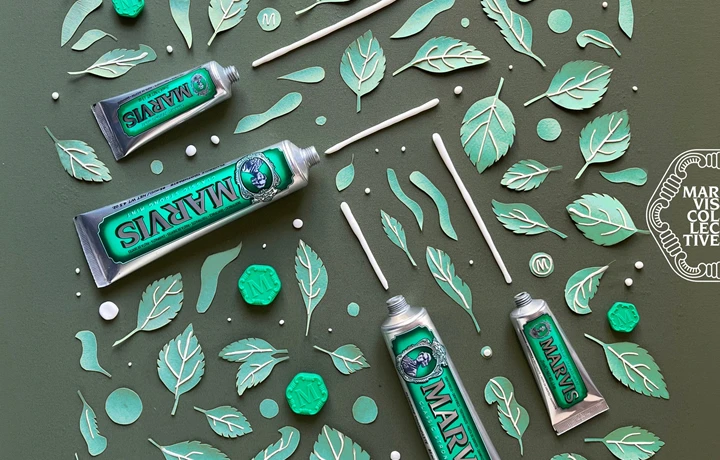 diversos dentífricos de la marca MARVIS en una composición creativa con hojas de menta 