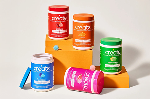 Envase de gomitas de creatina junto a sobres monodosis