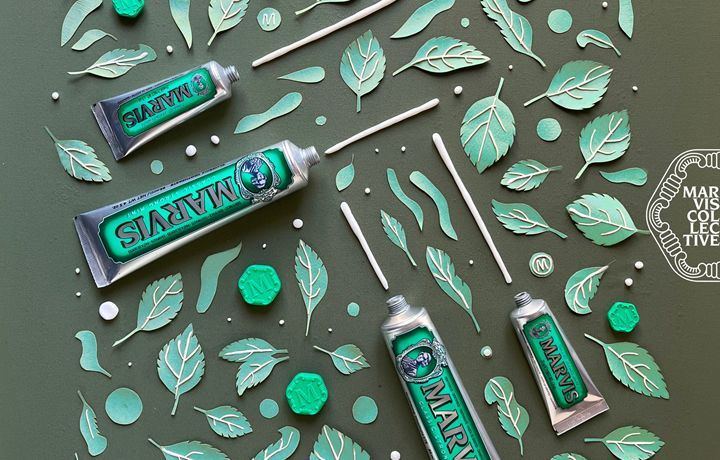 diversos dentífricos de la marca MARVIS en una composición creativa con hojas de menta 